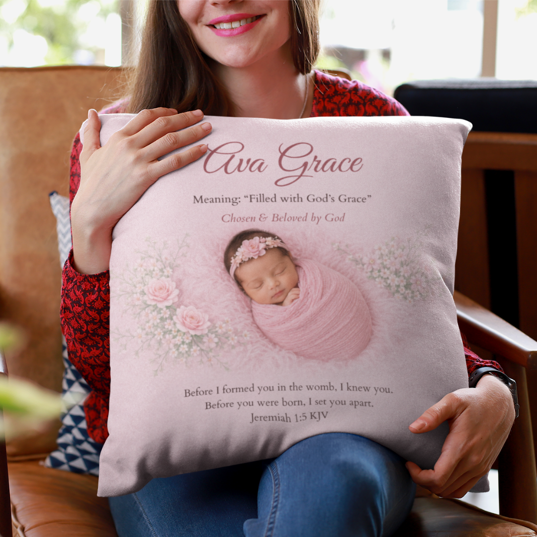 Person holding a pillow with a baby photo and text, sitting on a couch.