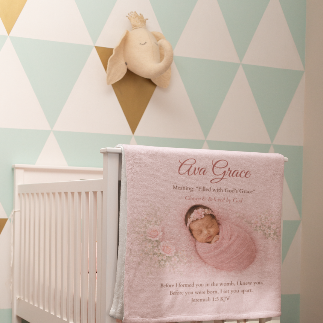 Baby blanket with a baby's name and a baby photo on a crib in a nursery with geometric wall design.