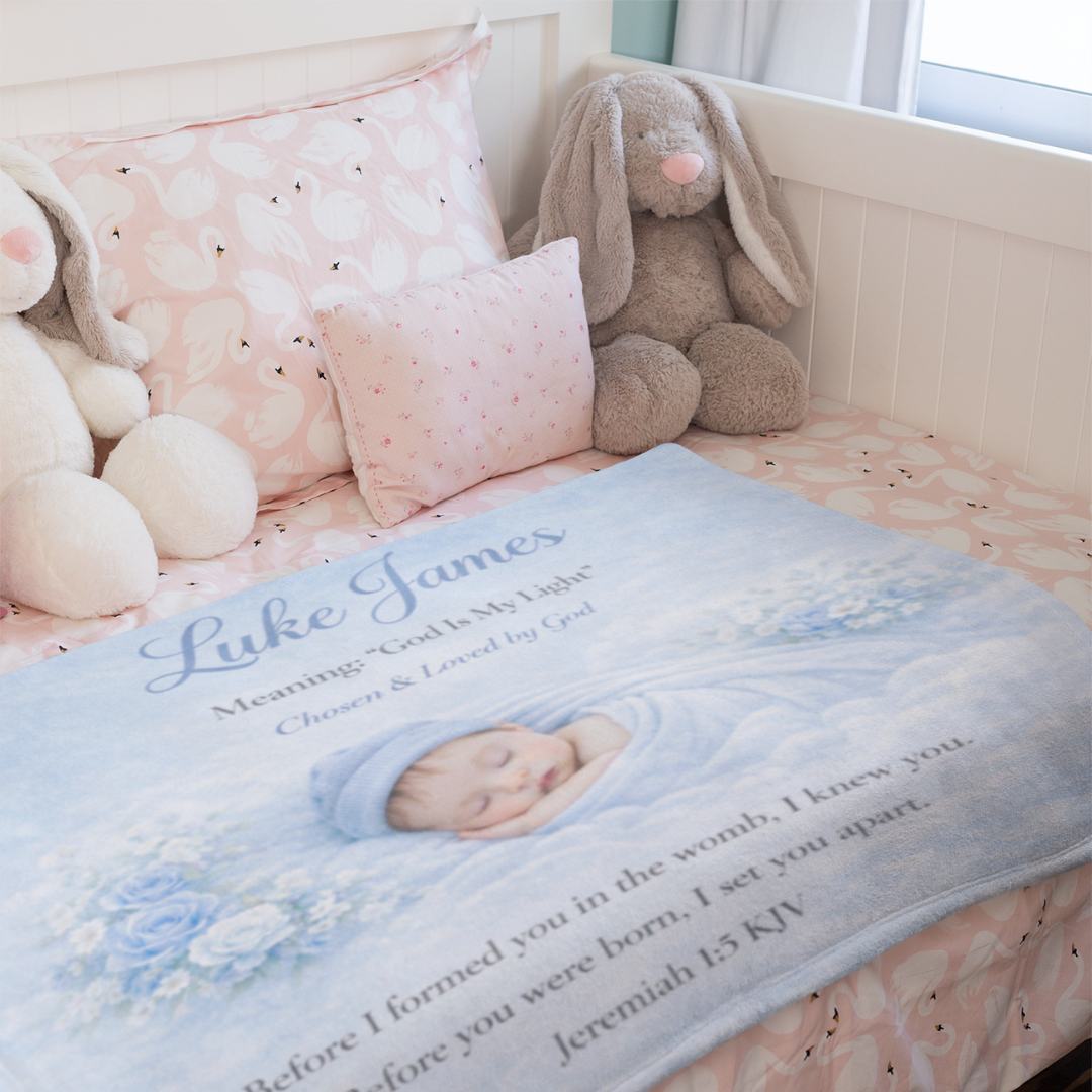 Baby blanket with a photo of a baby and text, placed on a crib with stuffed animals.
